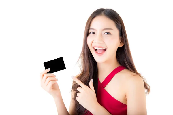 Asiática joven con vestido rojo sosteniendo una tarjeta de crédito pensando — Foto de Stock