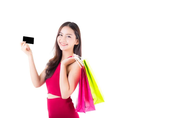 Asiática joven con vestido rojo sosteniendo una tarjeta de crédito y bolsa p — Foto de Stock