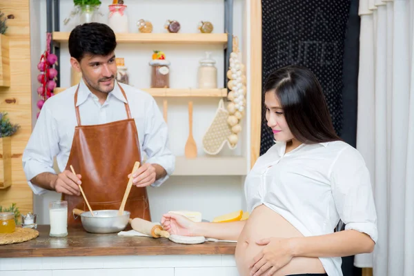 Marido feliz y esposa embarazada en la cocina, hombre asiático cocinar foo —  Fotos de Stock