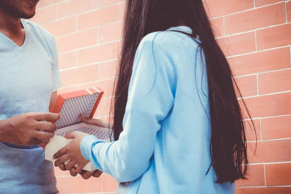 アジアのカップルの若い男は、屋外の女性に贈り物を与えます。ハッピーファミ — ストック写真