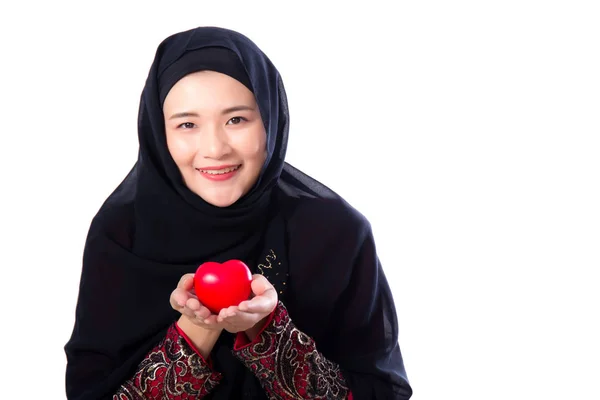 Retrato de joven mujer musulmana asiática sosteniendo corazón rojo en forma de pi — Foto de Stock