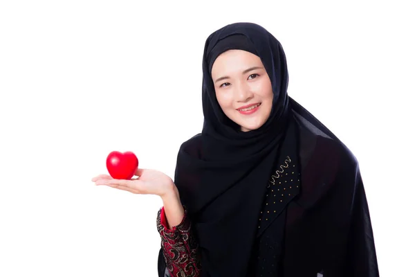 Retrato de joven mujer musulmana asiática sosteniendo corazón rojo en forma de pi — Foto de Stock