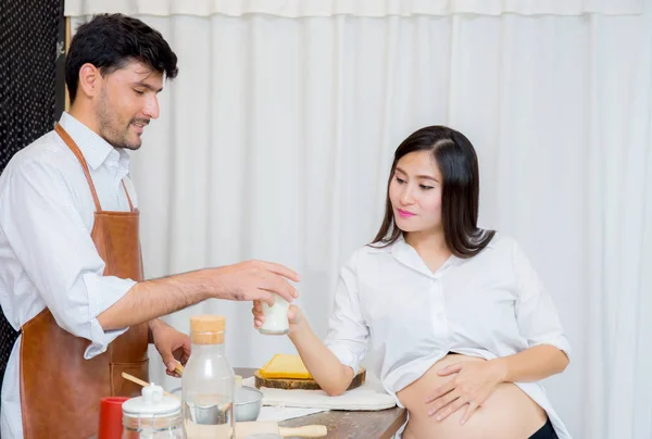 Marido feliz y esposa embarazada en la cocina, hombre asiático cocinar foo —  Fotos de Stock