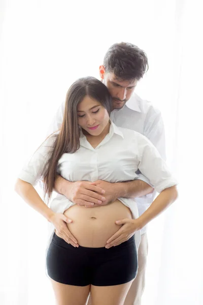 Embarazada madre y padre de pie abrazo celebración vientre, famil —  Fotos de Stock