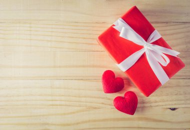 Hediye kutusu beyaz yay kurdele ve ahşap masa arka plan üst kalp