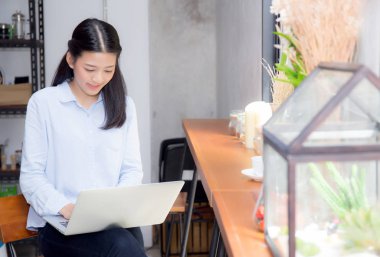 Güzel asya genç kadın dizüstü bilgisayar da oturan online çalışan 