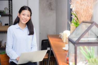 Güzel asya genç kadın dizüstü bilgisayar da oturan online çalışan 