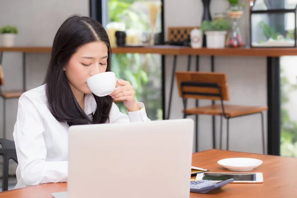 Krásná Asijská mladá žena pracuje online na laptopu a pije c — Stock fotografie
