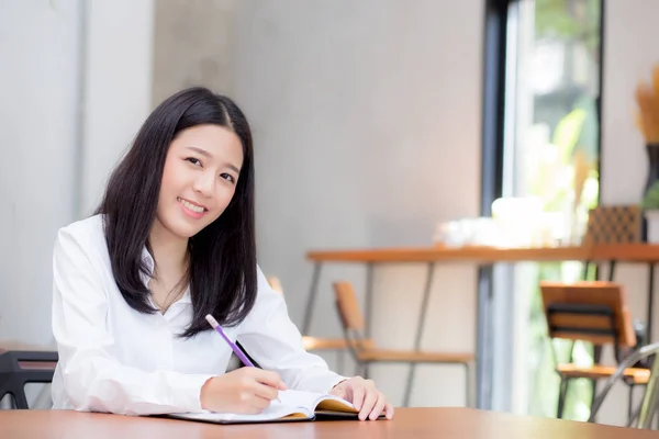 Beautiful business asian young woman writing on notebook on tabl — Stock Photo, Image