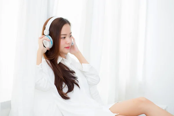 Vakker asiatisk ung kvinne liker å lytte musikk med hodetelefoner – stockfoto