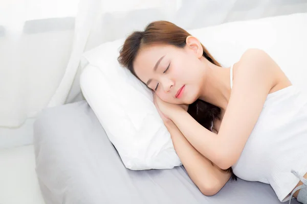 Красива азіатська молода жінка спить лежить в ліжку з головою на р — стокове фото