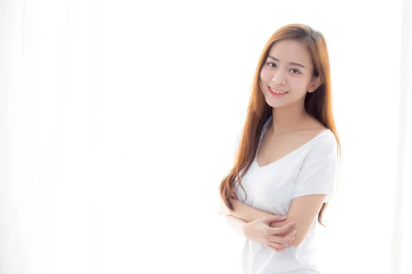 Vacker ung asiatisk kvinna stående fönstret och leende medan — Stockfoto