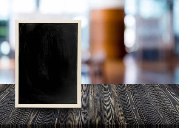 Leerer Holztisch mit Tafel im Restaurant verschwimmt Hintergrund — Stockfoto