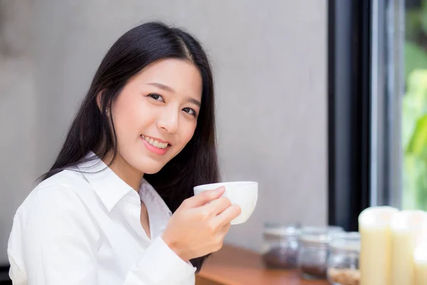 コーヒーを飲んで笑顔を見せる美しいアジアの若い女性 — ストック写真