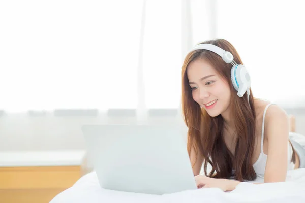 Vakker asiatisk ung kvinne som slapper av mens hun hører på musikk med hodestups – stockfoto