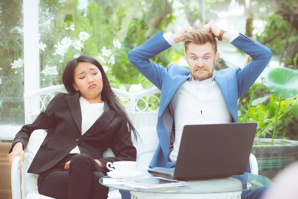 Two business surprised looking at laptop computer with shocked,