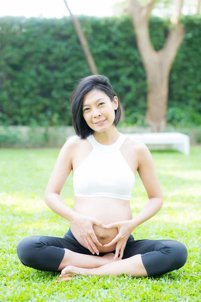 Feliz embarazada hermosa joven asiático mujer con gesto mano hea —  Fotos de Stock