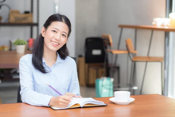 Krásná Asijská mladá žena píše na notebook na tabulky — Stock fotografie