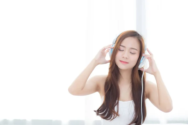 Hermosa mujer joven asiática disfrutar escuchar música con auriculares wh — Foto de Stock