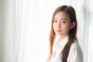 Pencerede duran güzel genç Asyalı kadının portresi ve 