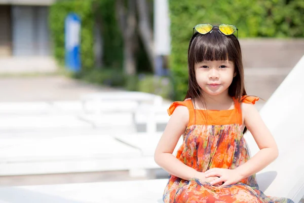 Beautiful portrait little girl asian of a smiling sitting at swi — Stock Photo, Image