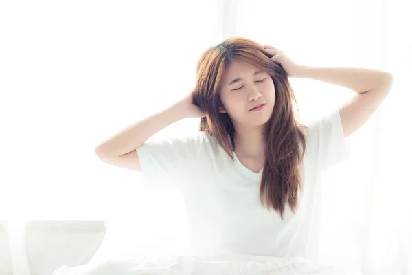 Güzel genç asyalı kadın streç ve uyandıktan sonra yatakta dinlenmek — Stok fotoğraf