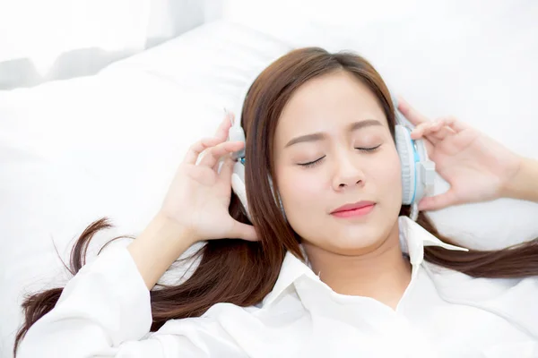 Hermosa mujer joven asiática disfrutar escuchar música con auriculares wh —  Fotos de Stock