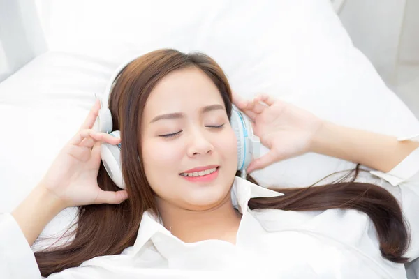 Hermosa mujer joven asiática disfrutar escuchar música con auriculares wh — Foto de Stock