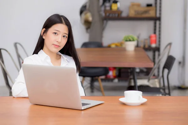 Krásná Asijská mladá žena pracuje online na přenosném počítači, který sedí na — Stock fotografie