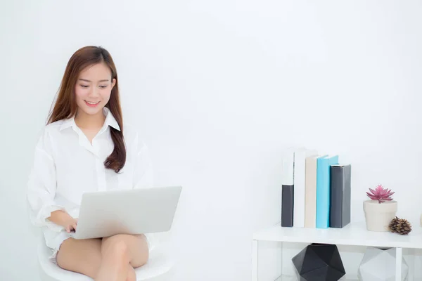 Krásná mladá asijská žena, která používá přenosný počítač pro volný čas na pohovce, GI — Stock fotografie