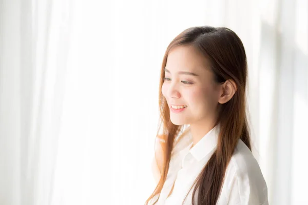 Retrato de hermosa joven asiática de pie la ventana y — Foto de Stock