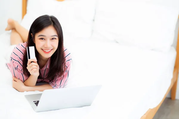 Hermoso retrato joven asiática mujer mintiendo usuarios tarjeta de crédito ingenio —  Fotos de Stock
