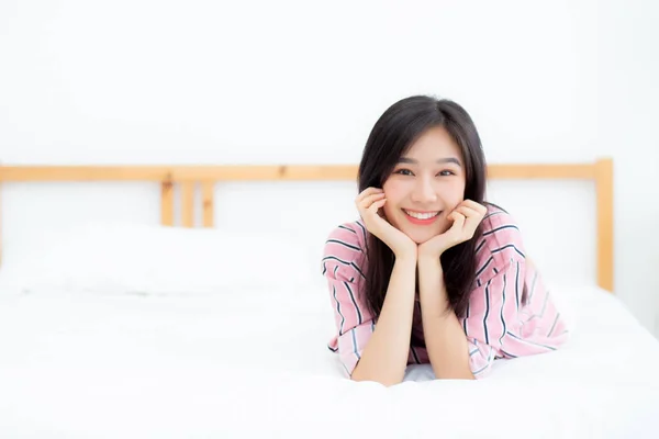 Hermoso retrato joven asiática mujer mintiendo y sonrisa mientras despierta —  Fotos de Stock