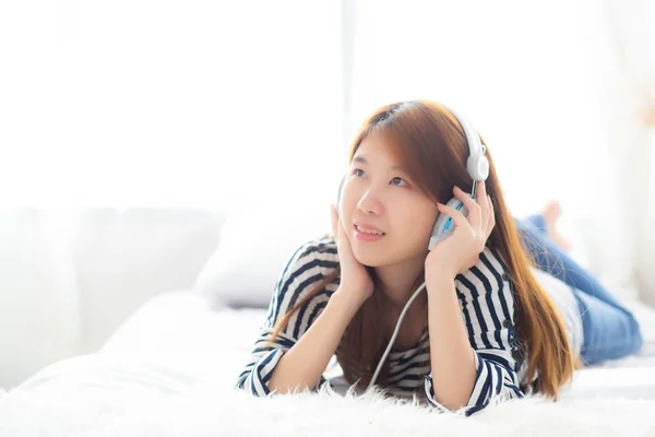 Vakker asiatisk ung kvinne nyter og morer seg lyttemusikk med hodet – stockfoto