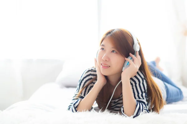 Mooie Aziatische jonge vrouw genieten en plezier luisteren muziek met hoofd — Stockfoto