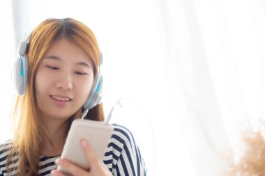 Güzel asyalı genç kadın kulaklık ile müzik dinlemek keyfini çıkarın bir