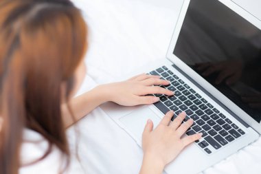 Closeup genç asyalı kadın yatak odasında eğlence için dizüstü bilgisayar kullanarak, g