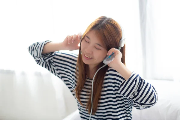 Hermosa mujer joven asiática disfrutar y divertido escuchar música con la cabeza —  Fotos de Stock