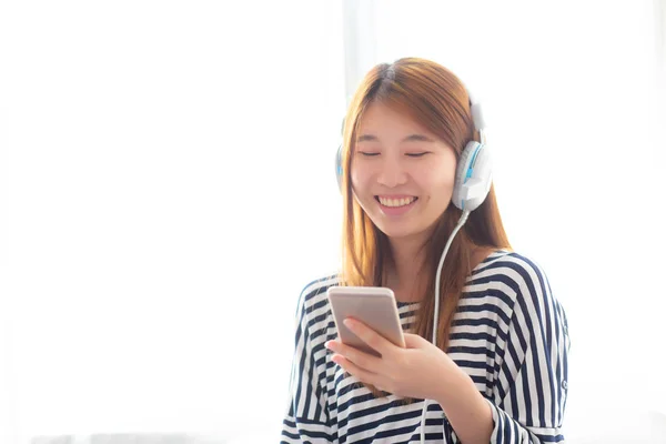 Hermosa mujer joven asiática disfrutar escuchar música con auriculares un —  Fotos de Stock