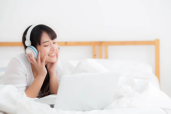 Bella giovane asiatica sdraiata in camera da letto con computer portatile calcolare — Foto Stock