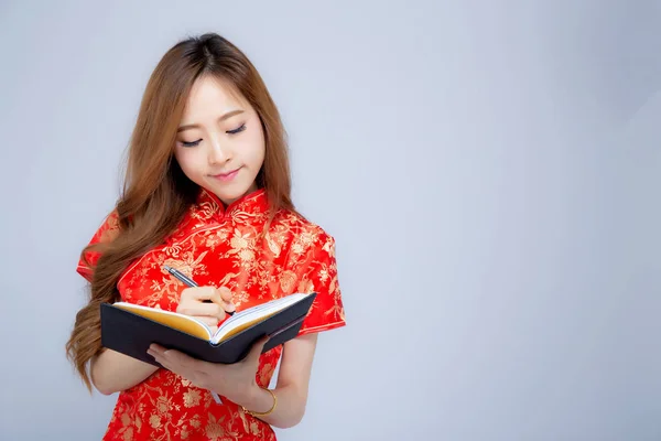 Güzel portre genç asyalı kadın kırmızı cheongsam yazma giymek — Stok fotoğraf