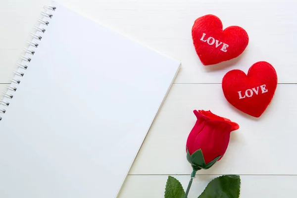 Present red rose flower and notebook and heart shape with copy s