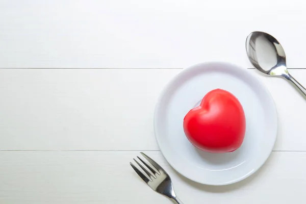 Coeur rouge avec amour et plat et cuillère et fourchette sur backgr en bois — Photo