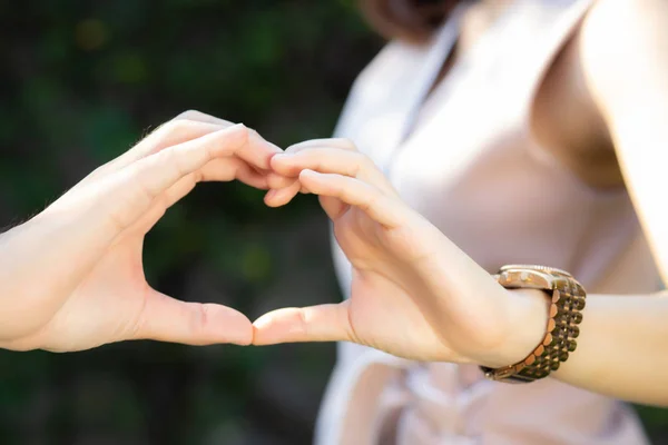 Closeup de feliz casal divertido fazendo gesto forma do coração com a mão — Fotografia de Stock