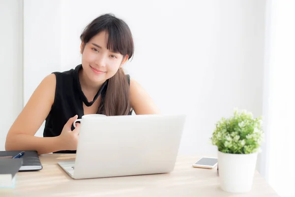 Beautiful young freelance asian woman smiling working and typing Stock Picture