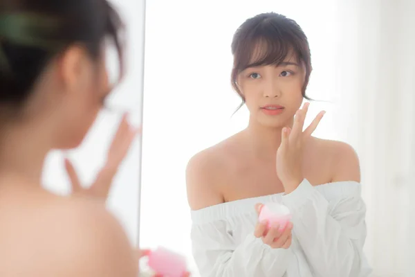 Hermoso retrato joven mujer asiática aplicando crema hidratante —  Fotos de Stock