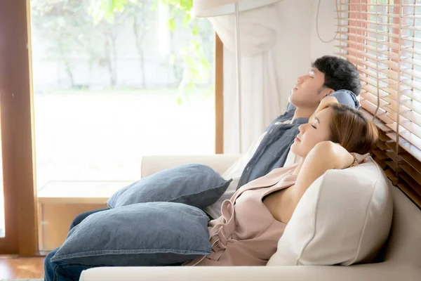 Joven asiática pareja sonrisa relajarse cómodo en sofá en la vida —  Fotos de Stock