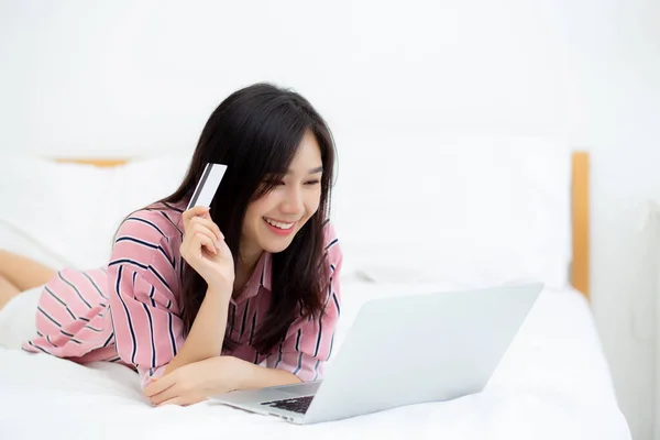 Hermosa de retrato joven mujer asiática mintiendo usuarios tarjeta de crédito —  Fotos de Stock