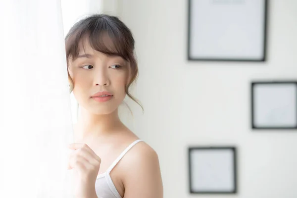 Retrato de bela jovem asiática mulher de pé na janela um — Fotografia de Stock