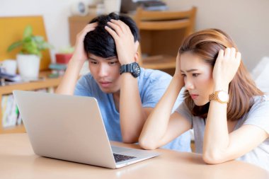 Genç Asyalı çift sorunun finansmanı konusunda endişeli ve stresli.